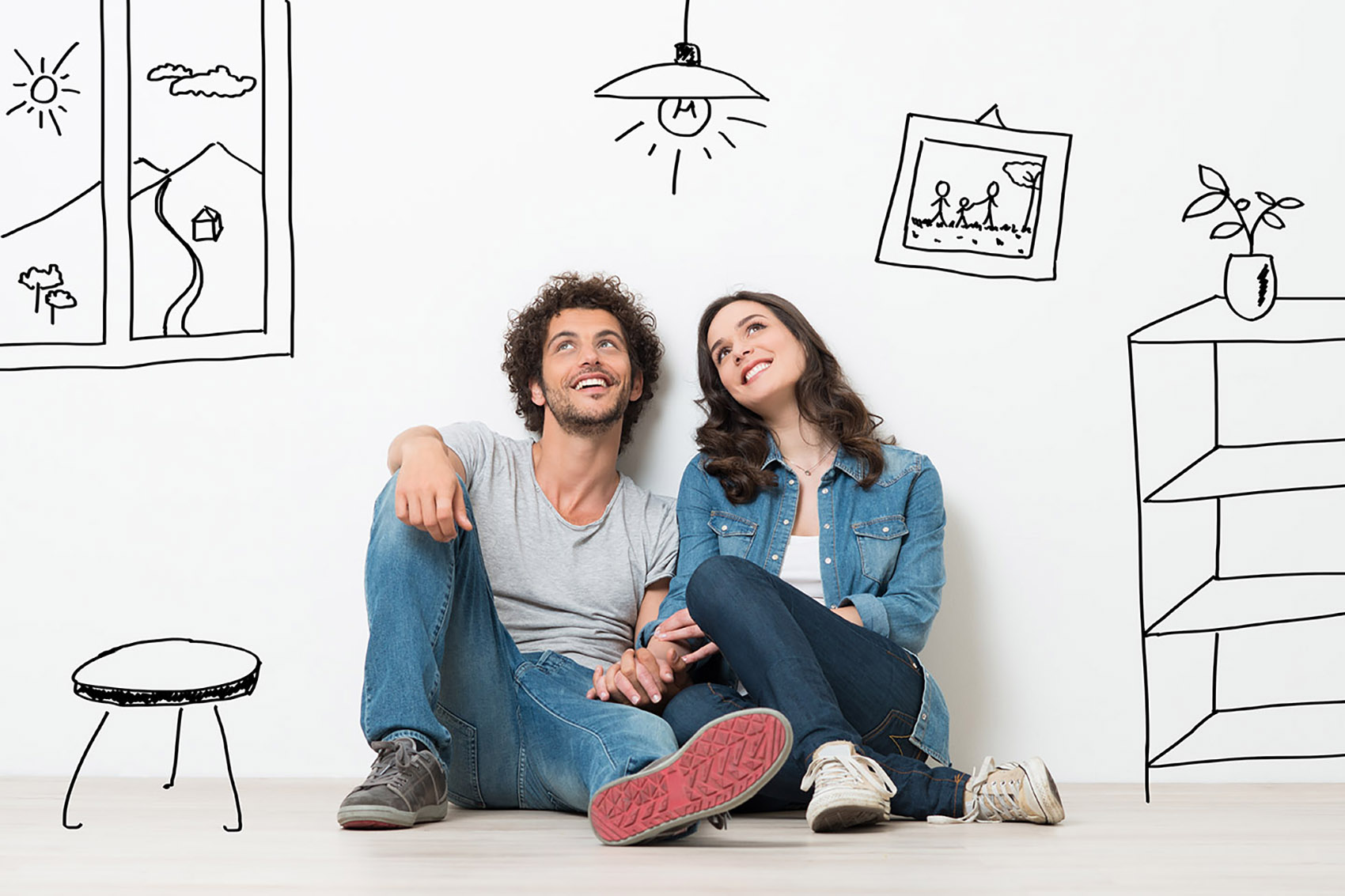 Portrait,of,happy,young,couple,sitting,on,floor,looking,up